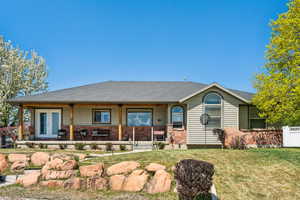 View of front of property with covered porch, roof with shingles, french doors, and a front lawn