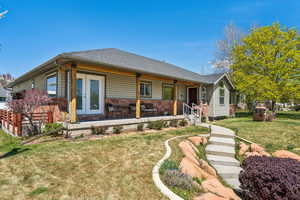 View of front of home featuring covered porch and a front yard