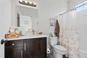 Full bathroom with toilet, vanity, and shower / bath combo