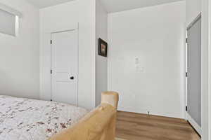 Bedroom featuring wood finished floors and baseboards