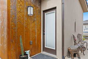 View of exterior entry featuring stucco siding