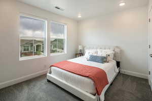 Bedroom featuring carpet floors, baseboards, and visible vents