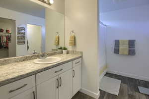 Full bath with vanity, baseboards, a shower with shower curtain, and wood finished floors