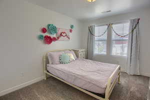 Bedroom with carpet flooring, baseboards, and visible vents