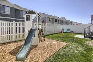 View of yard featuring a fenced backyard, a playground, and a residential view
