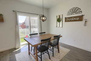 Dining room featuring baseboards, dark wood finished floors, a healthy amount of sunlight, and visible vents