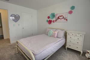 Carpeted bedroom featuring baseboards and visible vents