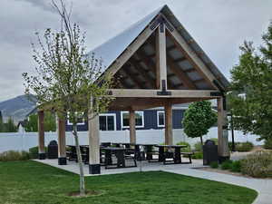 View of home's community with fence, a gazebo, and a lawn