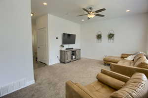 Carpeted living room featuring visible vents, recessed lighting, baseboards, and a ceiling fan