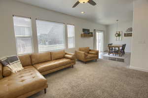 Living room with a ceiling fan, baseboards, recessed lighting, and carpet
