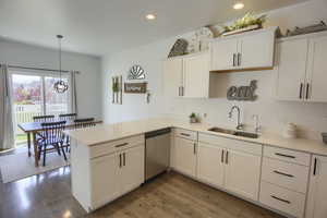 Kitchen featuring a sink, recessed lighting, white cabinetry, and dishwasher