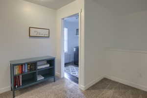 Corridor featuring baseboards and carpet flooring