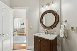 Bathroom with vanity, baseboards, and wood finished floors