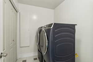Washroom featuring laundry area, washing machine and dryer, and baseboards