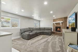 Living room featuring light colored carpet, recessed lighting, baseboards, and a fireplace
