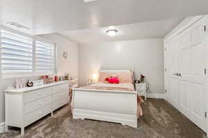 Bedroom with carpet floors, baseboards, visible vents, and a closet