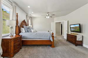 Carpeted bedroom featuring baseboards, a ceiling fan, and multiple windows