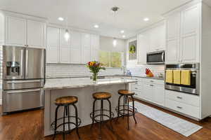 Kitchen featuring a sink, white cabinets, and stainless steel appliances