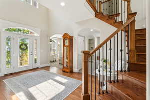 Entryway with arched walkways, a high ceiling, and stairs