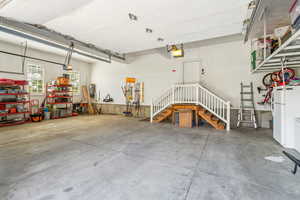 Garage with freestanding refrigerator and a garage door opener