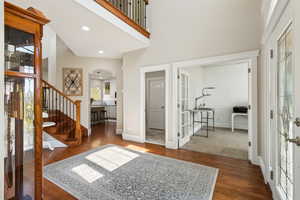 Foyer entrance with french doors, arched walkways, a high ceiling, and wood finished floors