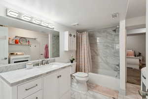 Bathroom with visible vents, marble finish floor, washer / dryer, and toilet