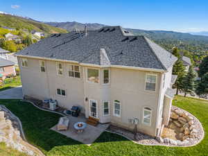 Rear view of house featuring roof with shingles, a patio, stucco siding, and central AC