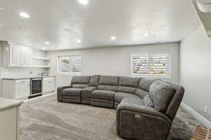 Living area featuring recessed lighting, wet bar, wine cooler, and baseboards