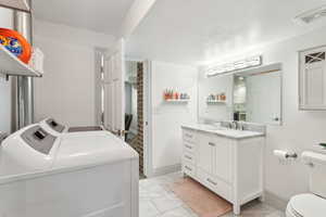 Clothes washing area with laundry area, marble finish floor, independent washer and dryer, and visible vents