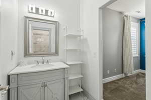 Bathroom featuring vanity, baseboards, and visible vents