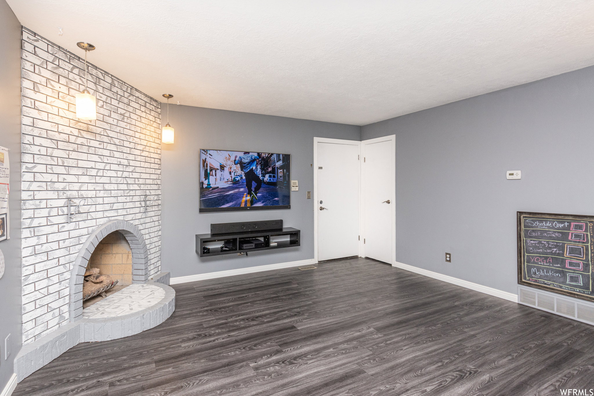 Unfurnished living room with a fireplace and dark wood-type flooring