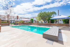 Community pool featuring fence, a residential view, and a patio area