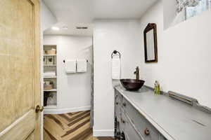 Bathroom with vanity, baseboards, visible vents, and recessed lighting