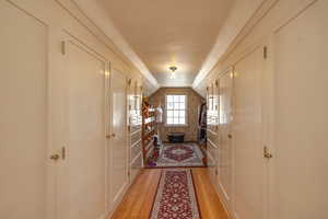 Hall featuring vaulted ceiling and light wood finished floors