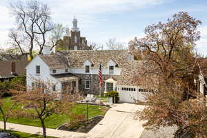 View of front facade with concrete driveway, fence, an attached garage, and stone siding