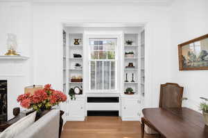 Interior space featuring radiator heating unit, a fireplace, crown molding, and wood finished floors
