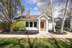 View of front of home featuring a front lawn, a shingled roof, and brick siding