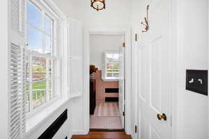 Hallway featuring tile walls and a wainscoted wall