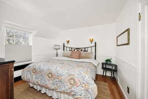 Bedroom featuring vaulted ceiling and wood finished floors