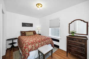 Bedroom with wood finished floors and baseboards