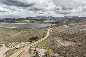 Drone / aerial view featuring a water and mountain view