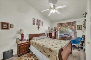Bedroom featuring lofted ceiling, ceiling fan, light carpet, and visible vents