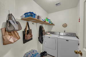 Laundry room with washer and dryer, laundry area, a textured ceiling, and visible vents