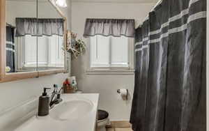 Full bath featuring toilet, tile patterned flooring, vanity, and a shower with shower curtain