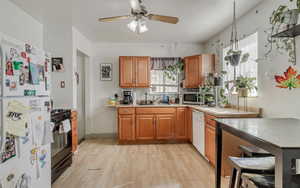 Kitchen featuring a sink, white appliances, light wood-type flooring, and plenty of natural light