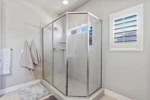 Bathroom with baseboards and a stall shower