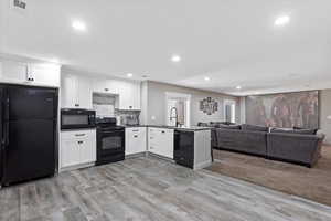 Kitchen featuring a sink, black appliances, visible vents, recessed lighting, and white cabinetry