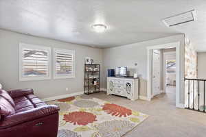 Living area featuring plenty of natural light, visible vents, and a textured ceiling
