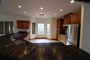 Kitchen with a sink, stainless steel appliances, recessed lighting, baseboards, and light wood-style floors