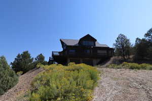 Rear view of property with stairway, a wooden deck, and metal roof